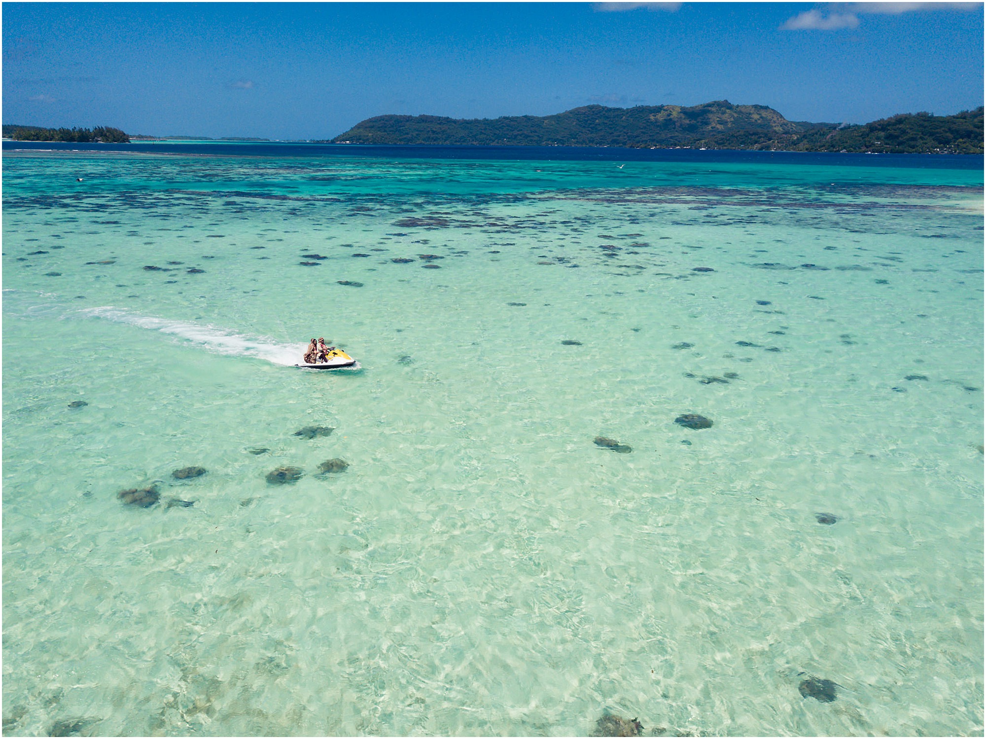 bora bora motu tapu bride and groom riding away in jetski